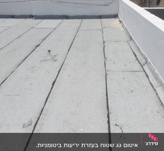 גג עם איטום ביטומני וסדקים שחורים